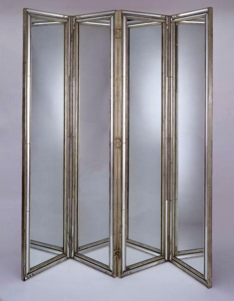 A mirrored folding screen designed by Syrie Maugham in 1935, featuring sleek Art Deco influences with reflective panels and a metallic frame.
